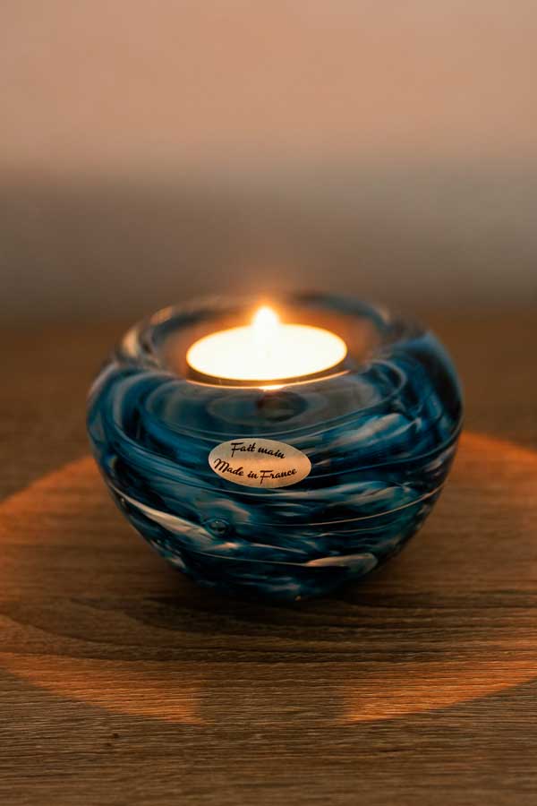 Bougeoir en cristal artisanal allumé, mettant en valeur la transparence et l’éclat du matériau