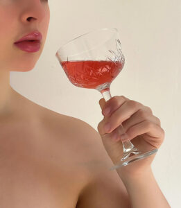 Verre à pied pour le vin posé sur une table élégante mettant en valeur la robe et la brillance du vin.